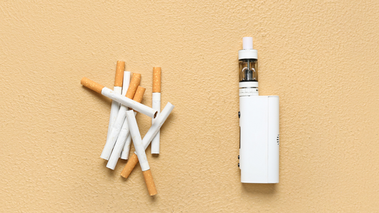 A scattered pile of broken cigarettes is on the left, contrasted by a sleek white e-cigarette on the right, set against a beige textured background.