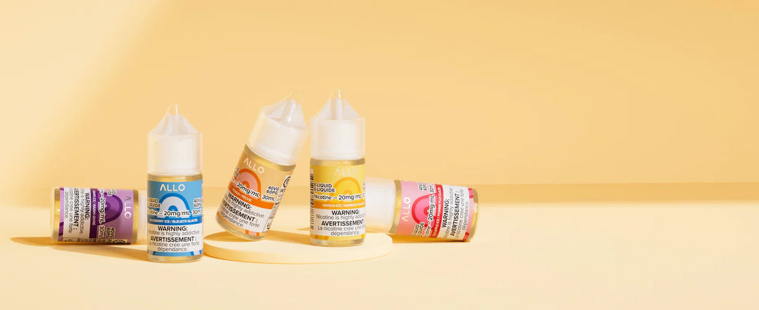 Five colorful e-liquid bottles, labeled "Allo," are arranged on a light yellow background. Some bottles are upright, others tilted, creating a vibrant, lively scene.